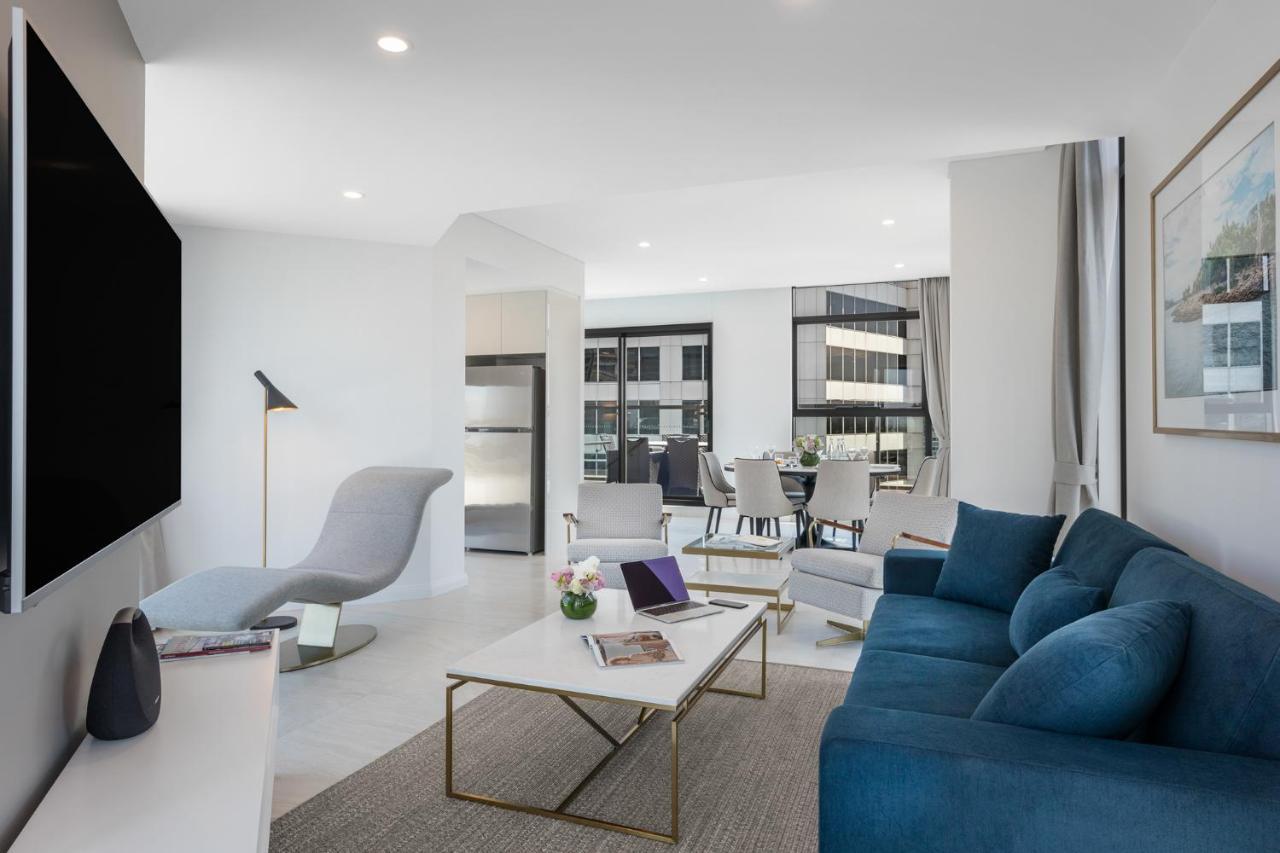 Meriton Suites Sussex Street, Σίδνεϊ Εξωτερικό φωτογραφία The photo shows a modern living space that features a bright and stylish interior. Key elements include:

- A sleek blue sofa and a light gray lounge chair, providing comfortable seating.
- A coffee table with a minimalist design, positioned in front