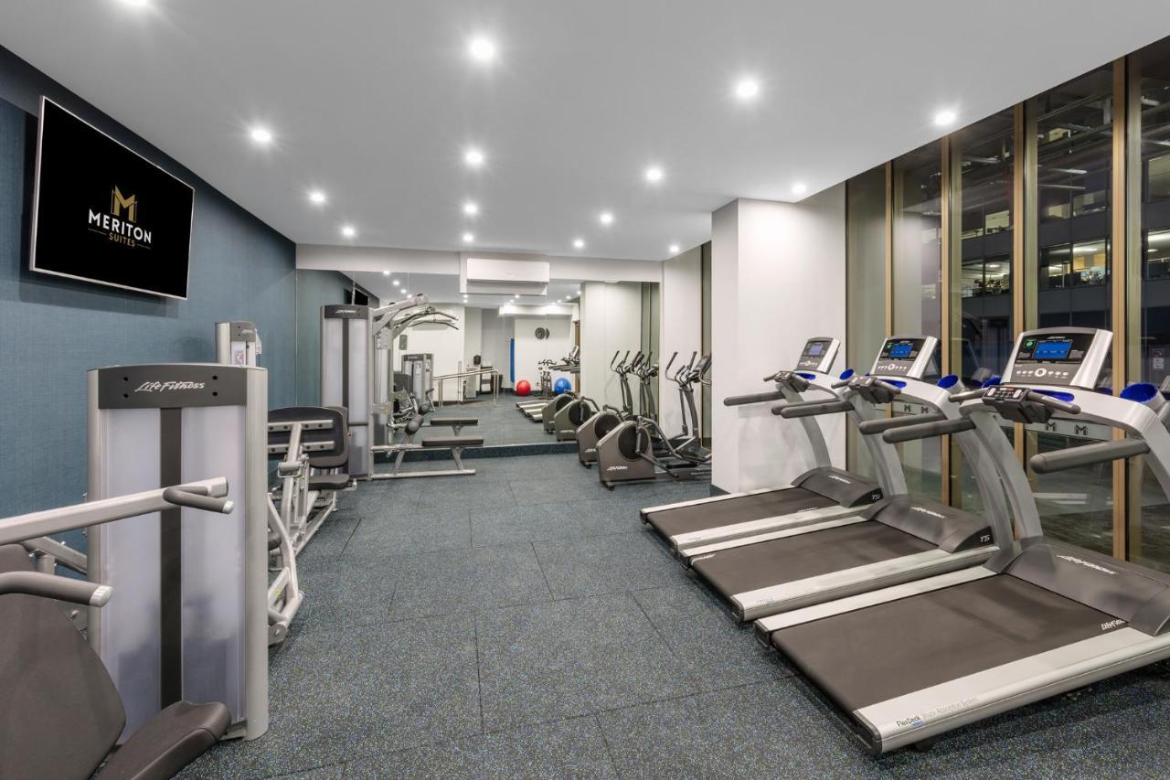 Meriton Suites Sussex Street, Σίδνεϊ Εξωτερικό φωτογραφία The photo shows a modern gym space. It features various exercise equipment, including several treadmills and elliptical machines positioned along one side. On the other side, there are weight machines and additional fitness equipment. The gym has a c