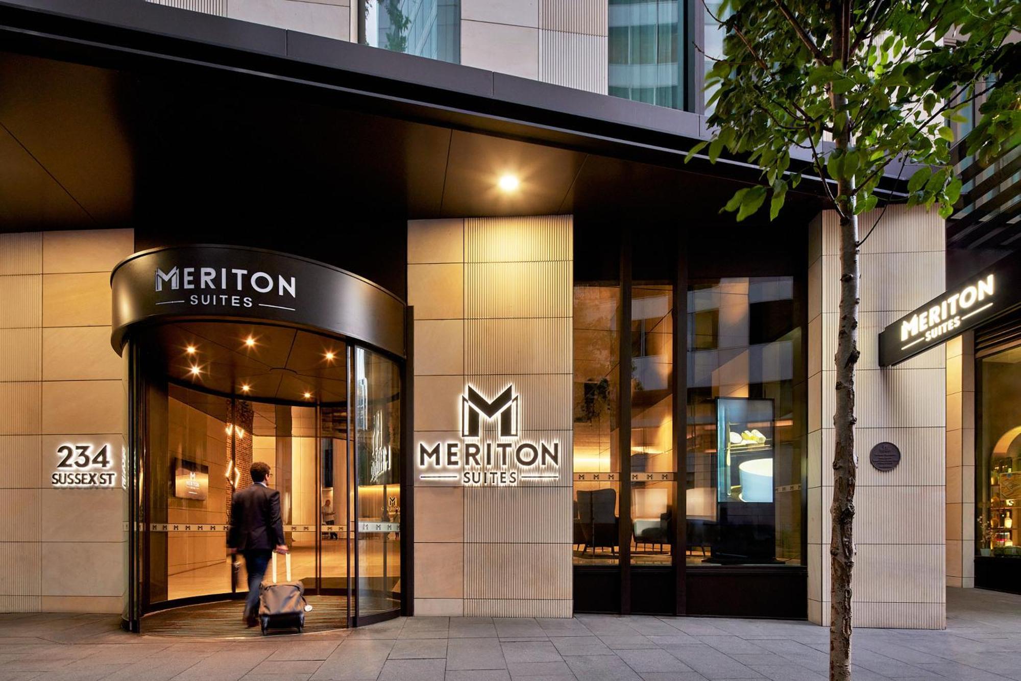 Meriton Suites Sussex Street, Σίδνεϊ Εξωτερικό φωτογραφία The photo shows the entrance of a hotel or suite establishment named "Meriton Suites." The entrance features a revolving door and a large, illuminated sign with the name "MERITON SUITES." The facade is modern and sleek, with a combination of glass an